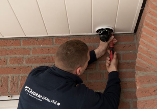 Camera en alarm samen: eigen monteur aan het werk bij een woning
